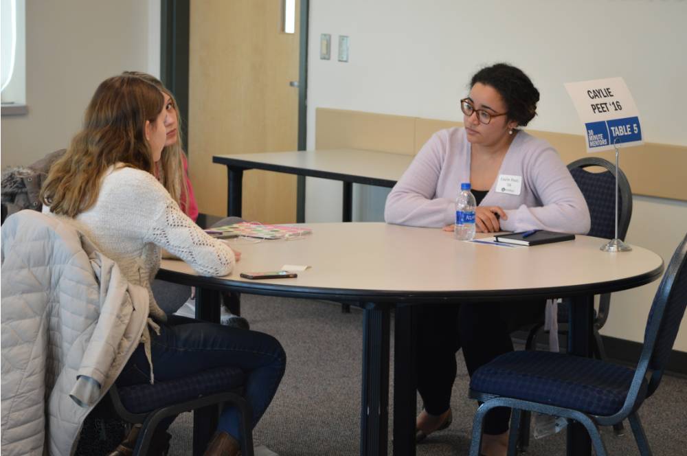 Caylie Peet talking to two students at the 30 Minute Mentors Event